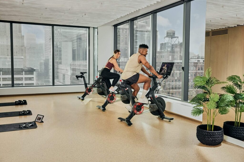 two people working out on Peloton bikes